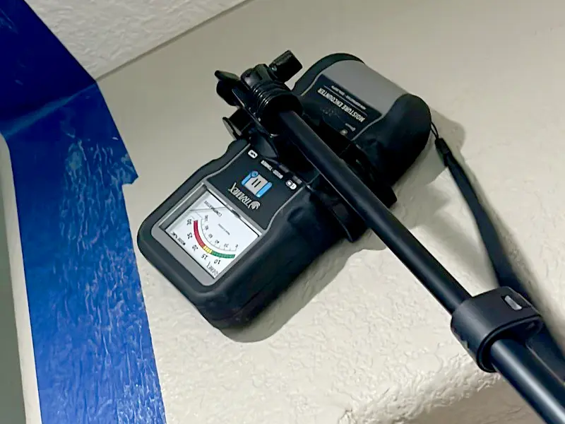 using moisture meter device on wall